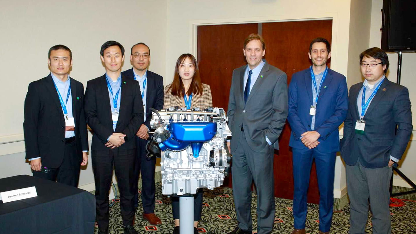 Aramcons (from left to right) Yuanjiang Pei, Ji-Woong Park, Yu Zhang, Le Zhao, David Cleary, Rafael Lago Sari and Anqi Zhang gather in front of an engine the company designed at the ASME ICE Forward Conference.