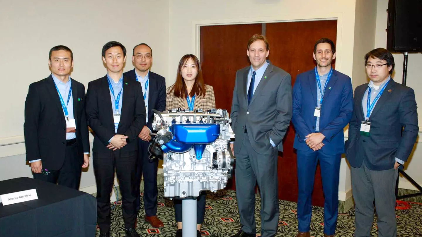 Aramcons (from left to right) Yuanjiang Pei, Ji-Woong Park, Yu Zhang, Le Zhao, David Cleary, Rafael Lago Sari and Anqi Zhang gather in front of an engine the company designed at the ASME ICE Forward Conference.